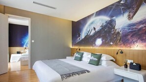 A modern hotel room with a large bed, a nightstand, and a wall mural depicting a space scene. - Happy Air Hotel (Jiande) (Jiande)