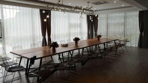 A conference room with a long table, chairs, and a chandelier. - Happy Air Hotel (Jiande) (Jiande)