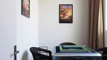 Una habitación con un escritorio, dos sillas, una puerta y un cartel en la pared.