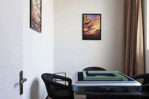 A room with a desk, two chairs, a door, and a poster on the wall. - Happy Air Hotel (Jiande) (Jiande)