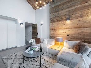 Relax in this stylish living room with a sofa, coffee table, and vase of flowers, set against a striking accent wall.