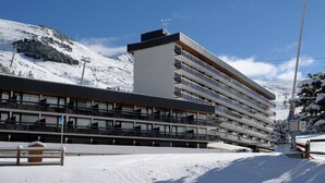 A multi-story hotel with a modern design, featuring balconies on each floor. - Renovated studio for 4 at slopeside - La Croisette (Les Belleville)