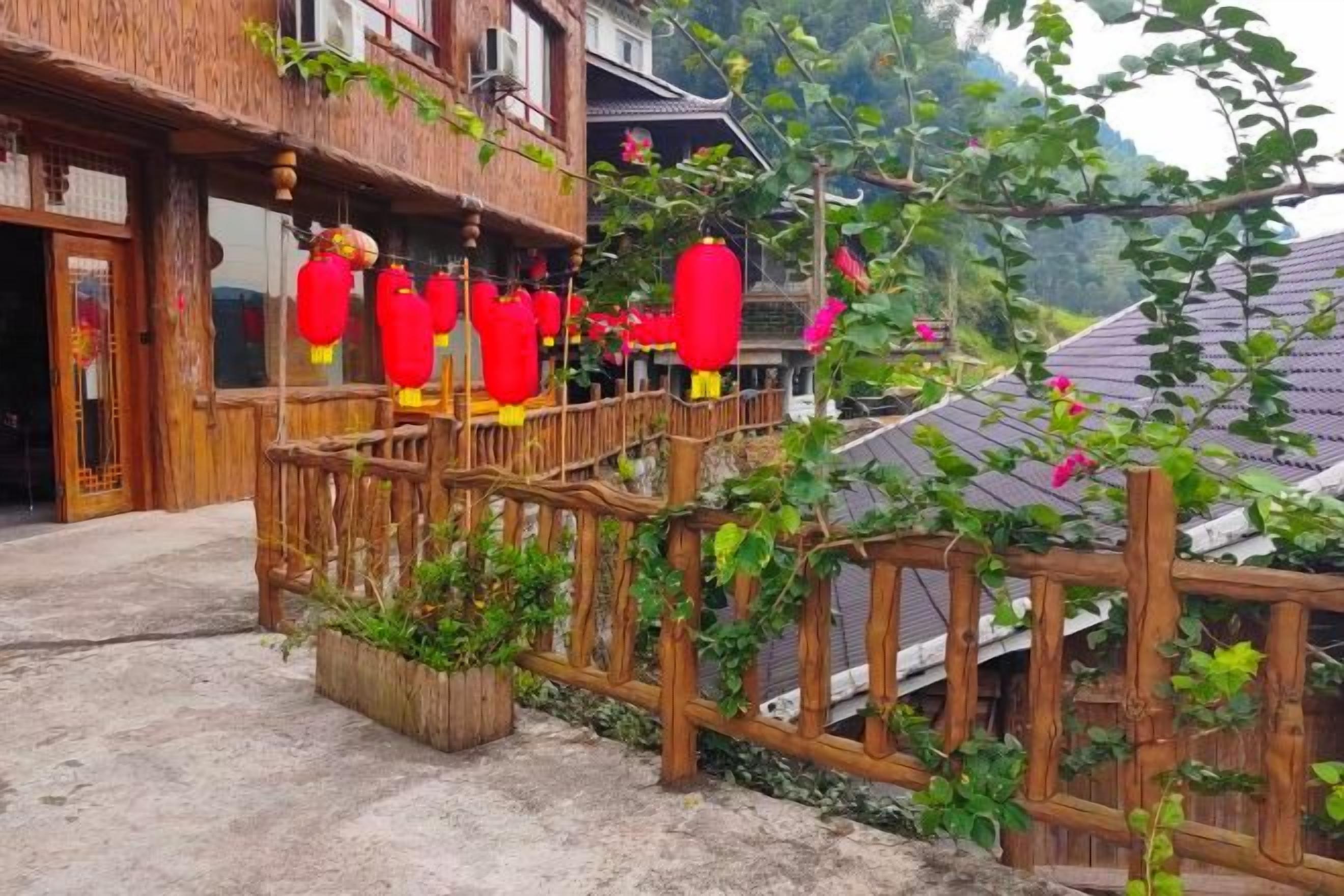 A traditional building with a wooden balcony and red lanterns.
