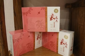 Three boxes with Chinese characters and a decorative border, placed on a wooden surface. - Bo Yuan Mei Yu Hotel (Zhuhai)
