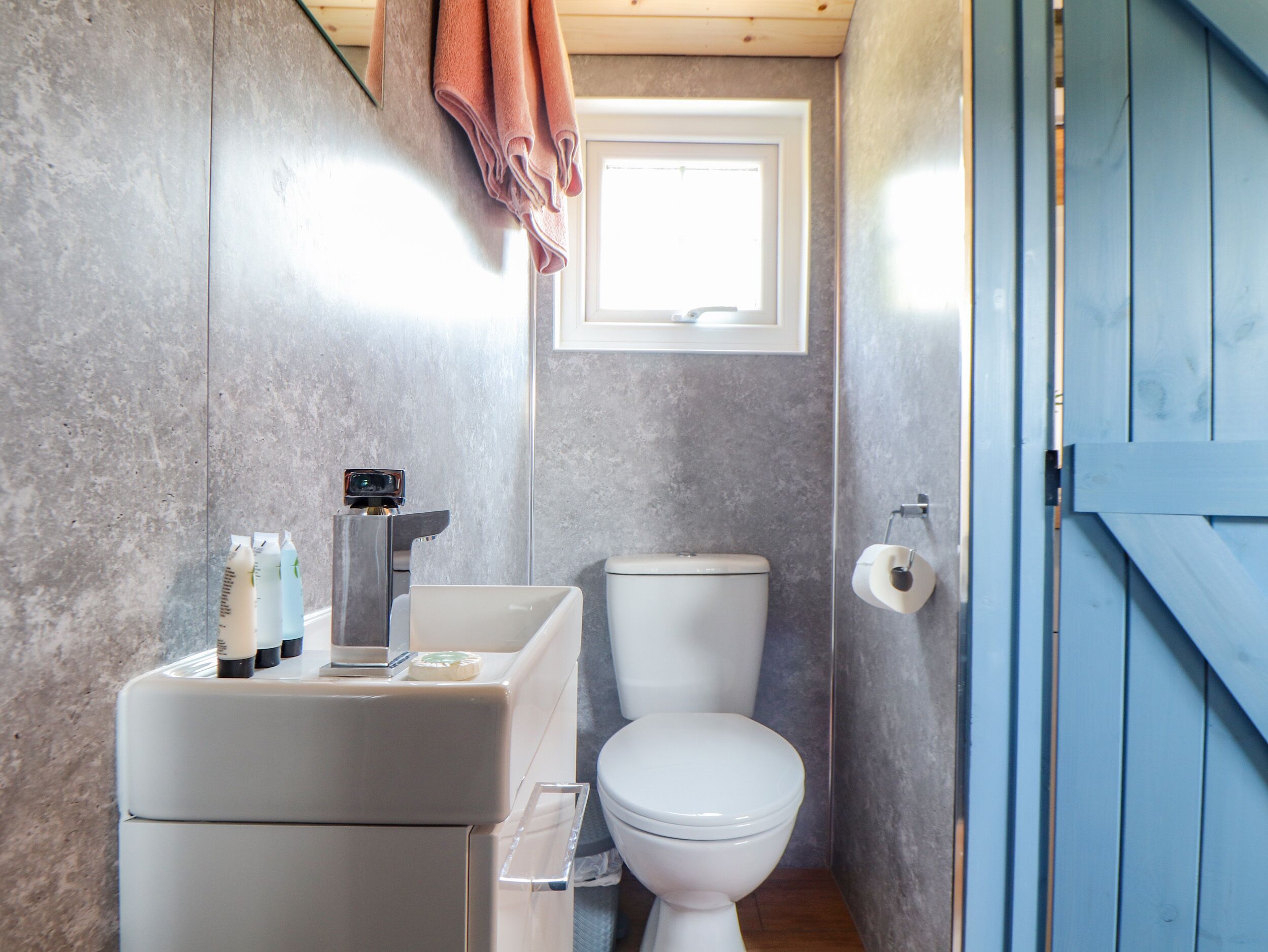 Un bagno compatto con il water, un lavandino e una piccola finestra.