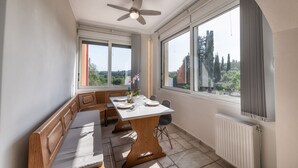 Un comedor con una mesa dispuesta para dos personas, un banco y vistas al exterior.