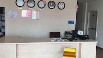Una recepción con relojes, una computadora y una silla.