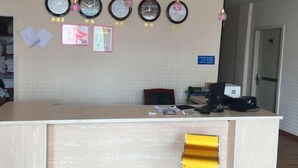 Una reception con orologi, quadri appesi e una insegna.
