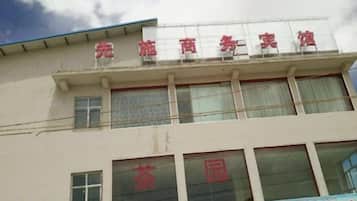 Un edificio con un letrero que dice 'Edificio Comercial Completo' y otro letrero debajo que dice 'Primer Edificio Comercial del Condado de Zhaozhou'.