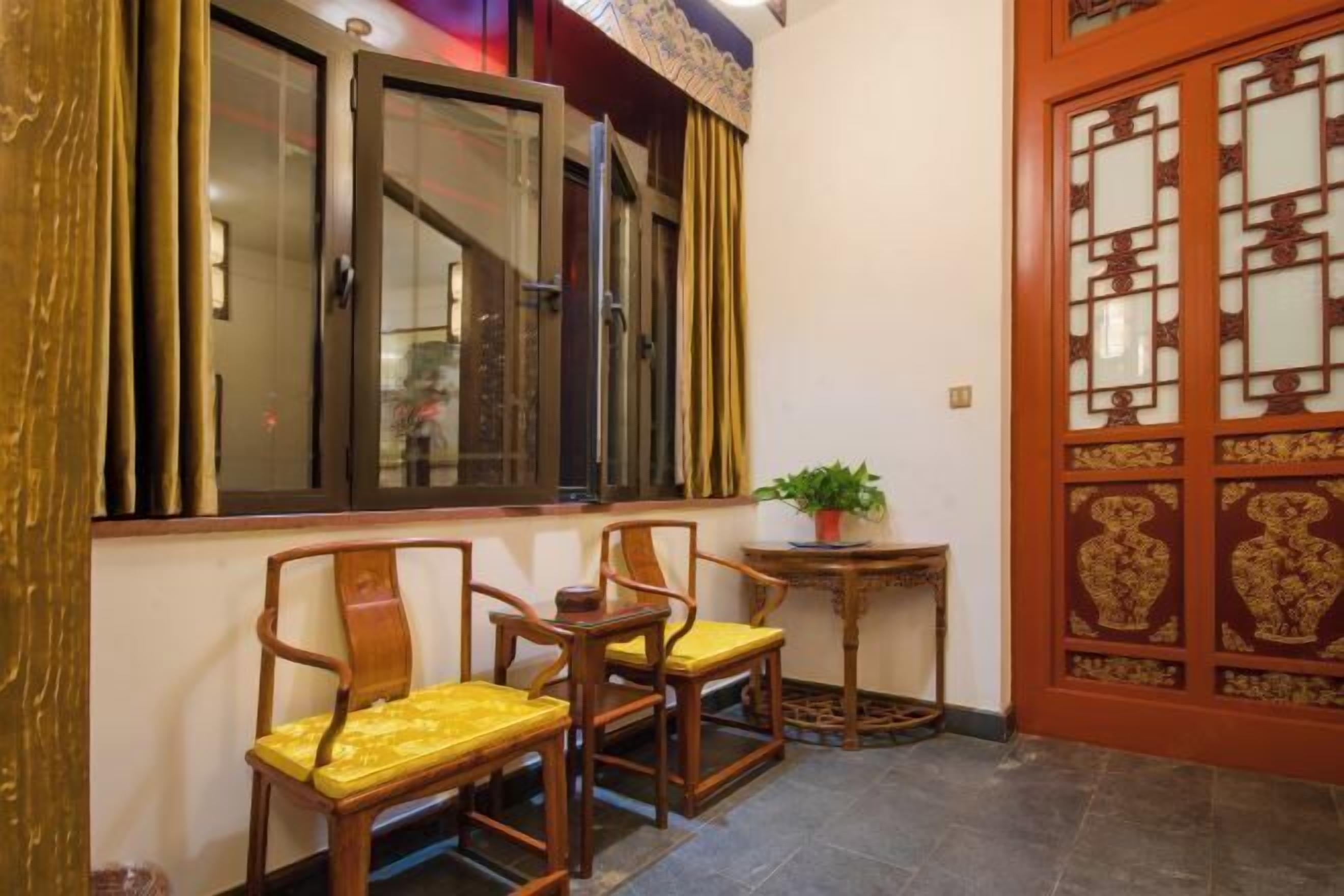 A traditional room with a wooden door, a window with a curtain, and a small table with a plant.