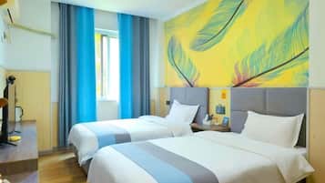 Une chambre d’hôtel avec deux lits, une grande fenêtre avec des rideaux, un tableau au mur et un bureau avec une lampe.