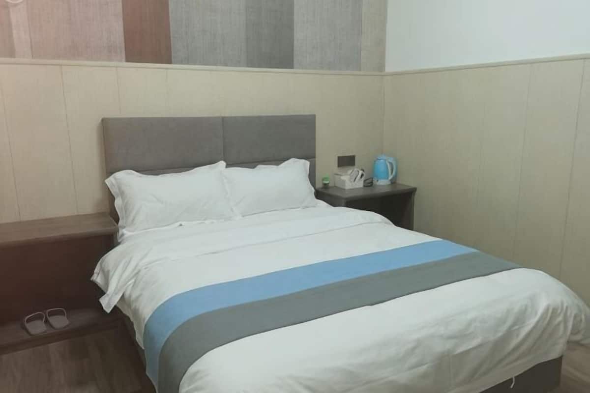 A hotel room with a bed, nightstand, and a telephone.