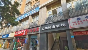 A multi-story building with various storefronts, including a pharmacy, a beauty salon, and a hotel. - Aishang City Inn (Chongqing)