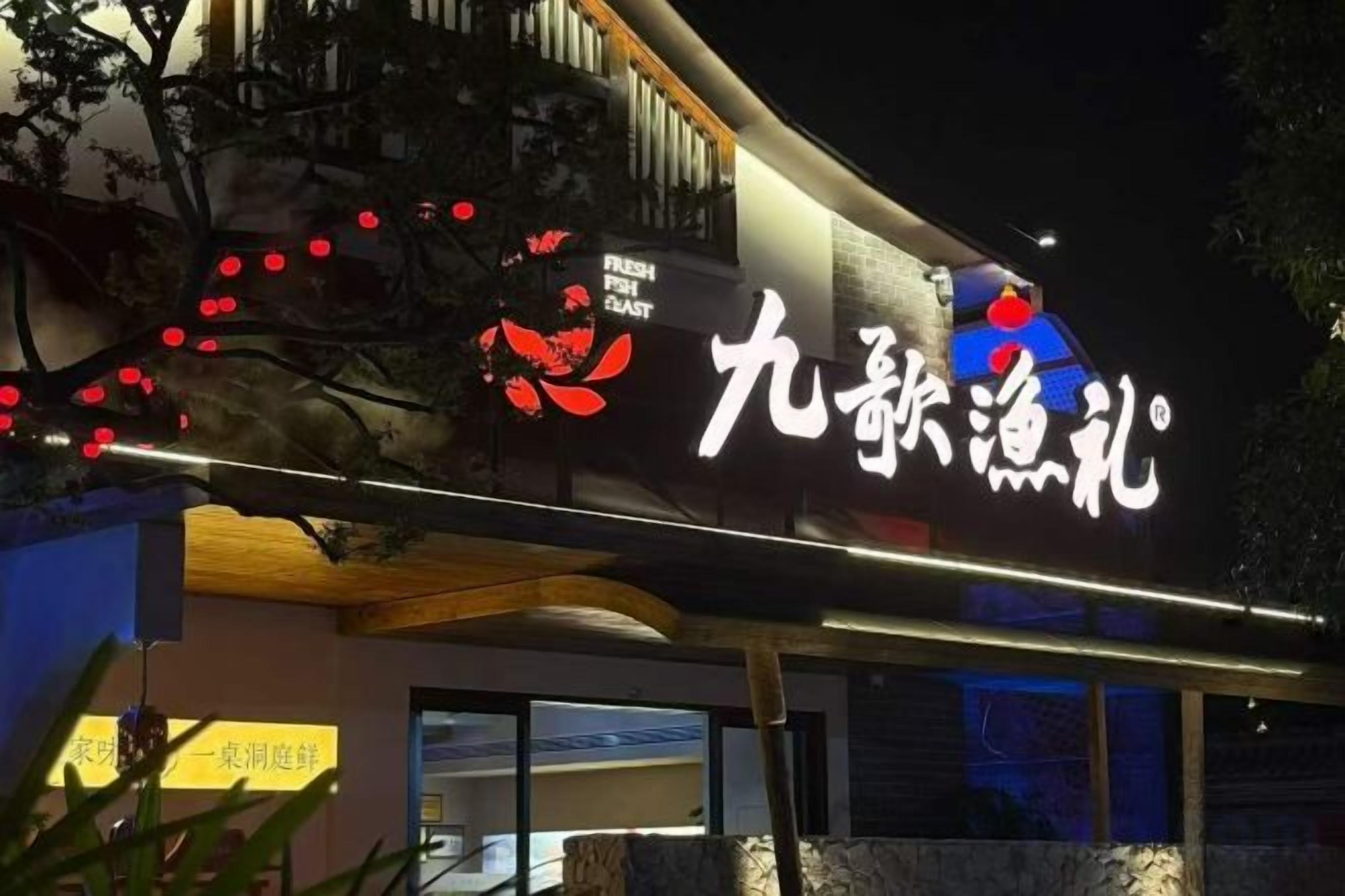 Un letrero de restaurante con caracteres chinos y un logotipo.