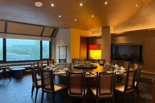 Un comedor moderno con una mesa redonda, sillas y un gran ventanal.