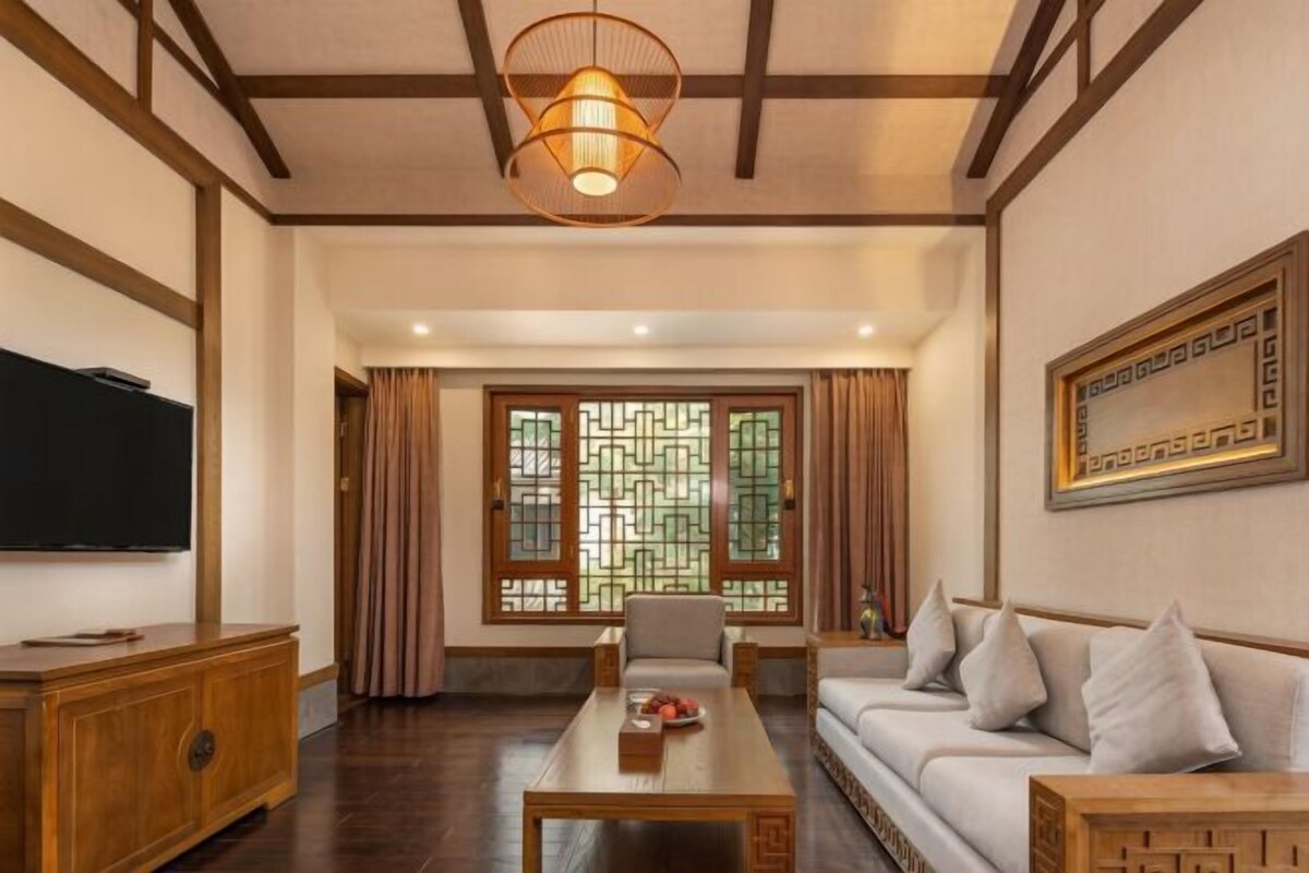 A traditional-style living room with a sofa, coffee table, and television.