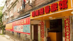 Un hôtel avec une enseigne jaune vif et une banderole rouge faisant la publicité de ses services.