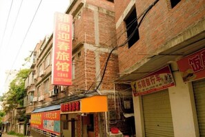 Una calle con varios edificios de ladrillo, algunos con carteles visibles.