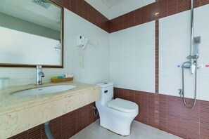 A bathroom with a sink, toilet, and shower. - Tingtaoju Hotel (Taishan)