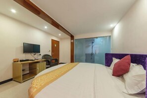 A hotel room with a bed, a desk, a television, and a sliding door leading to a bathroom. - Tingtaoju Hotel (Taishan)