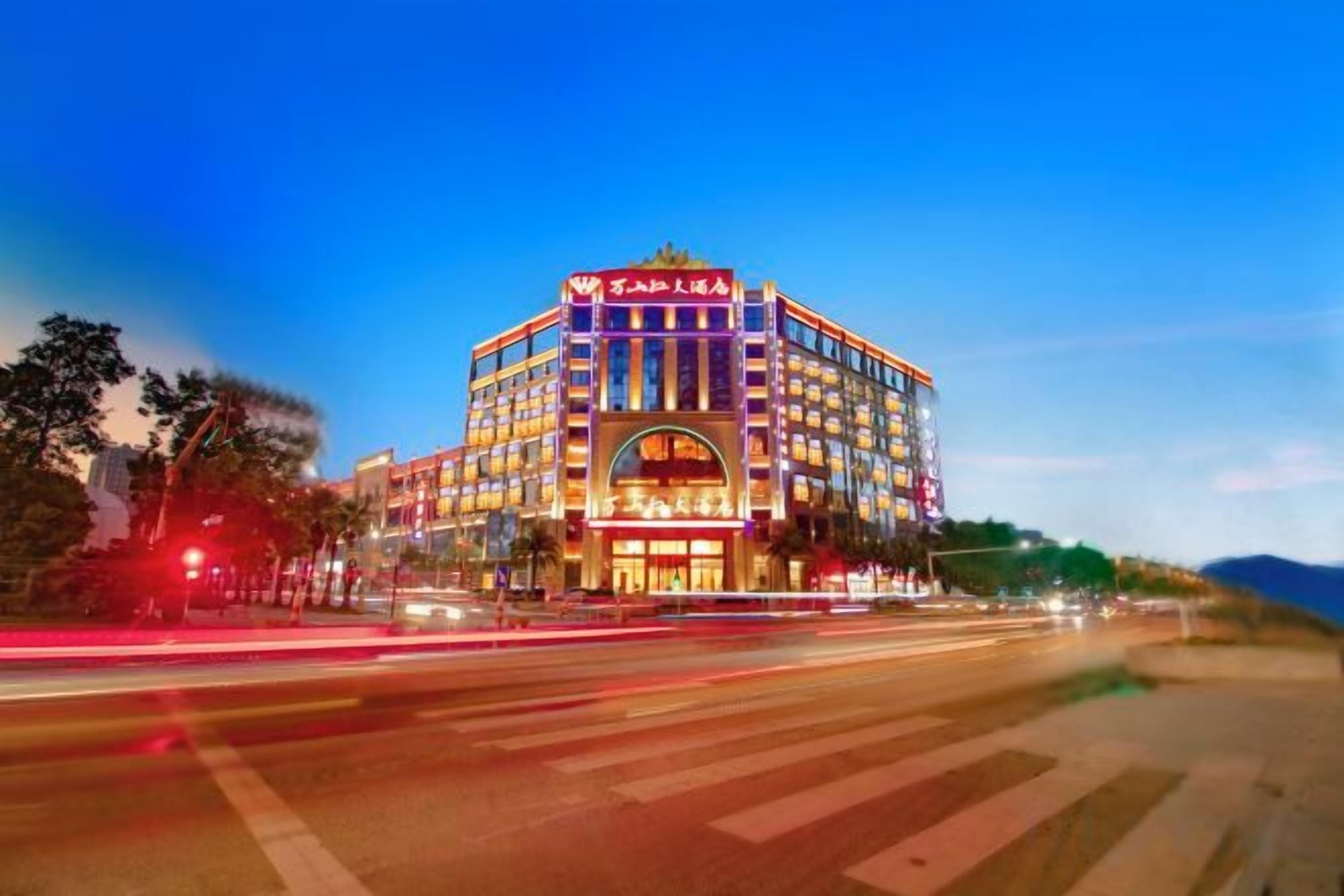A multi-story hotel with a prominent entrance and a large arched window.