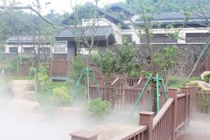 Un bâtiment de style japonais traditionnel, doté d’une clôture en bois et agr émenté de verdure.