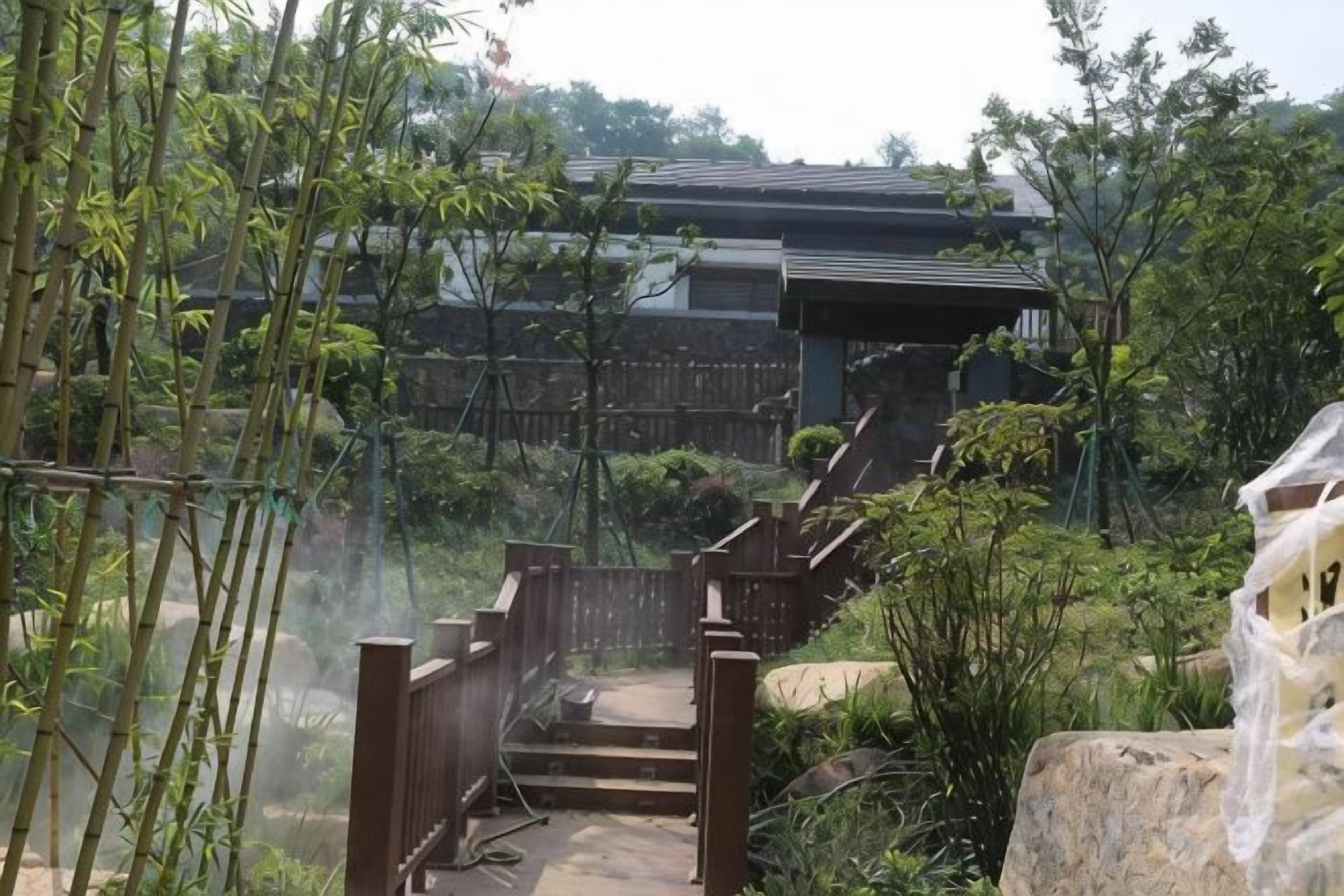 A traditional Japanese-style building with a wooden staircase leading to a gate.
