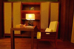 A room with a wooden desk, a chair, a lamp, and a shelf with books and a box. - Chuishan Hot Spring Resort (Zhenjiang)