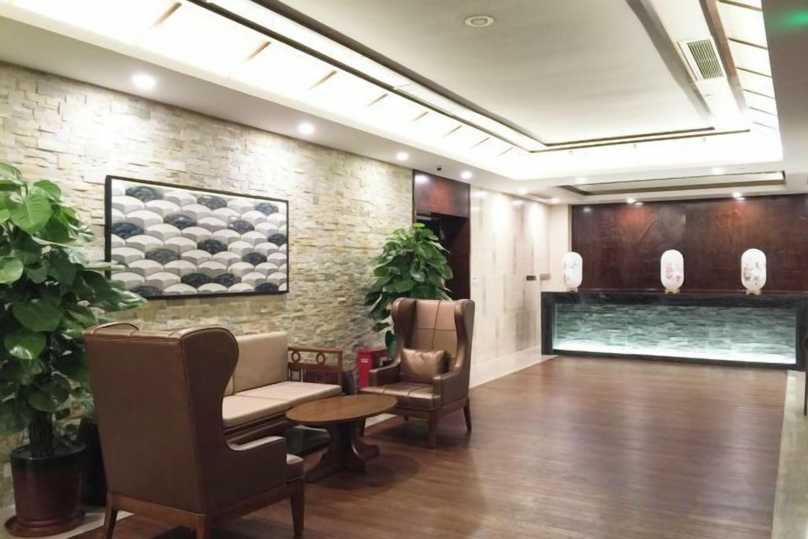 A lobby with a stone wall, seating area, and a water feature.