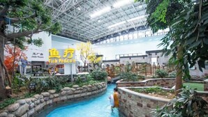 An indoor pool area with a Jade Room sign, surrounded by plants and a stone wall. - Chuishan Hot Spring Resort (Zhenjiang)