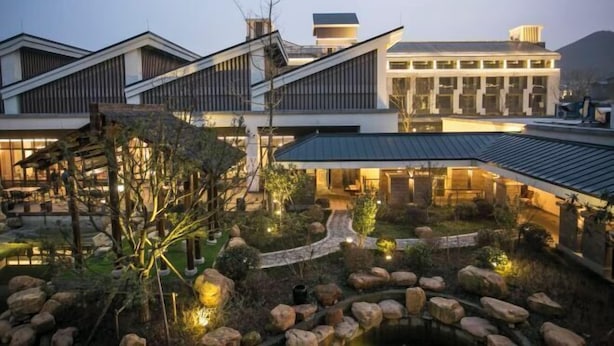 A modern building with a garden and a pond. - Chuishan Hot Spring Resort (Zhenjiang)