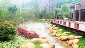 A traditional-style building with a stone pathway leading to a small stream. - Chuishan Hot Spring Resort (Zhenjiang)