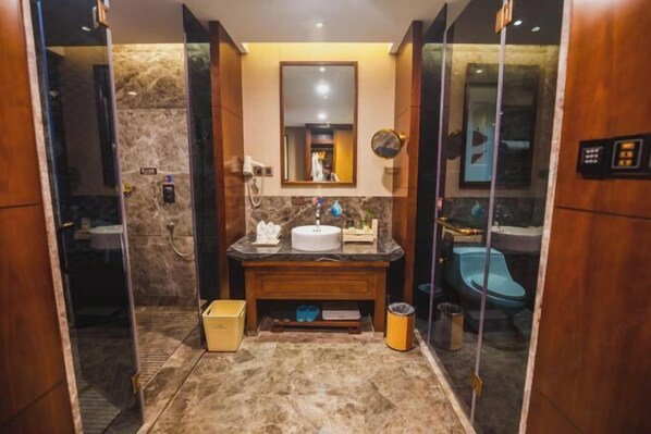 A modern bathroom with a marble floor, a wooden vanity, a mirror, and a blue toilet. - Chuishan Hot Spring Resort (Zhenjiang)