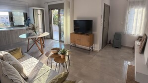 Een moderne woonkamer met een bank, een eettafel en een televisie.