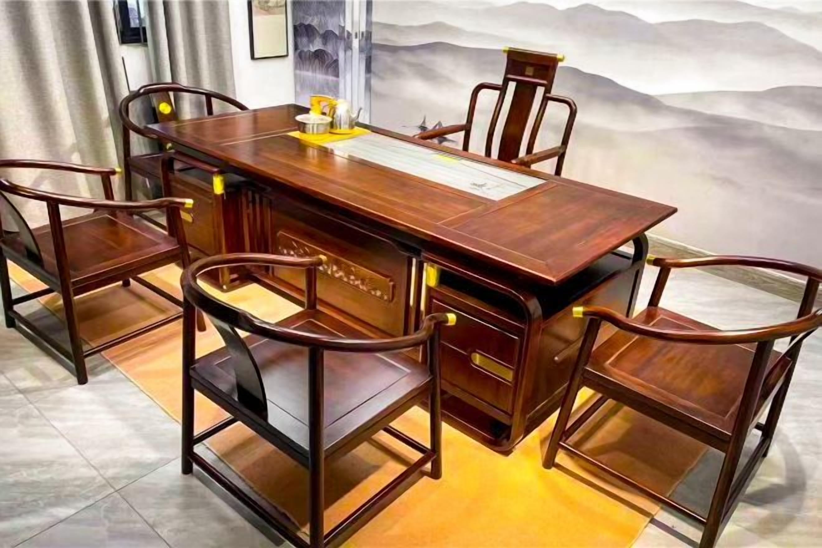 A wooden dining table with chairs, a decorative tray, and a scenic wall mural.