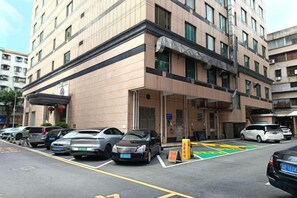 Un hôtel à plusieurs étages avec un parking situé à l’avant.