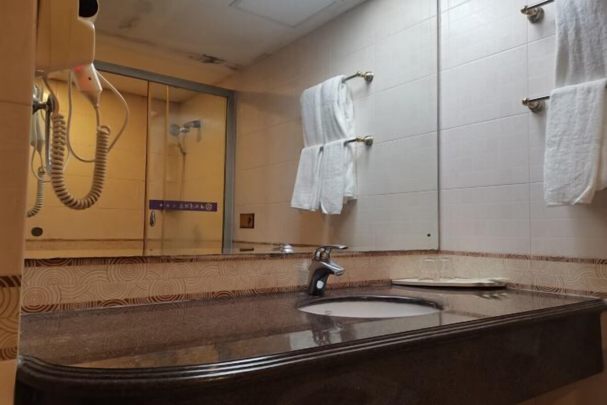 A bathroom with a sink, mirror, and towel rack.