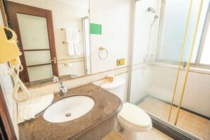 A bathroom with a sink, toilet, and shower. - Century Star Hotel (Foshan)