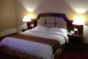A hotel room with a large bed, two bedside tables with lamps, and a headboard. - Century Star Hotel (Foshan)