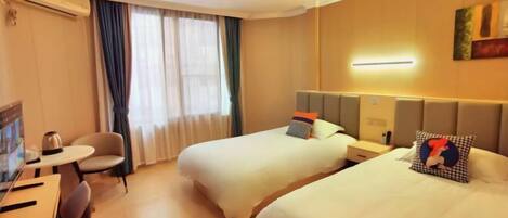 Quarto de hotel com duas camas, uma escrivaninha e uma cadeira.