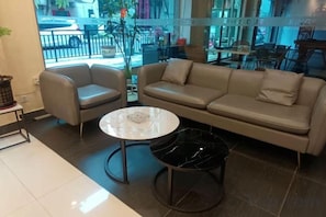 Un intérieur moderne avec un canapé, deux fauteuils et une table ronde.