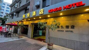 A Kings Hotel with a prominent entrance, outdoor seating area, and potted plants.