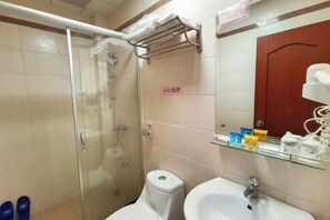 Une salle de bain avec une douche à parois de verre, un lavabo blanc et un miroir au-dessus.