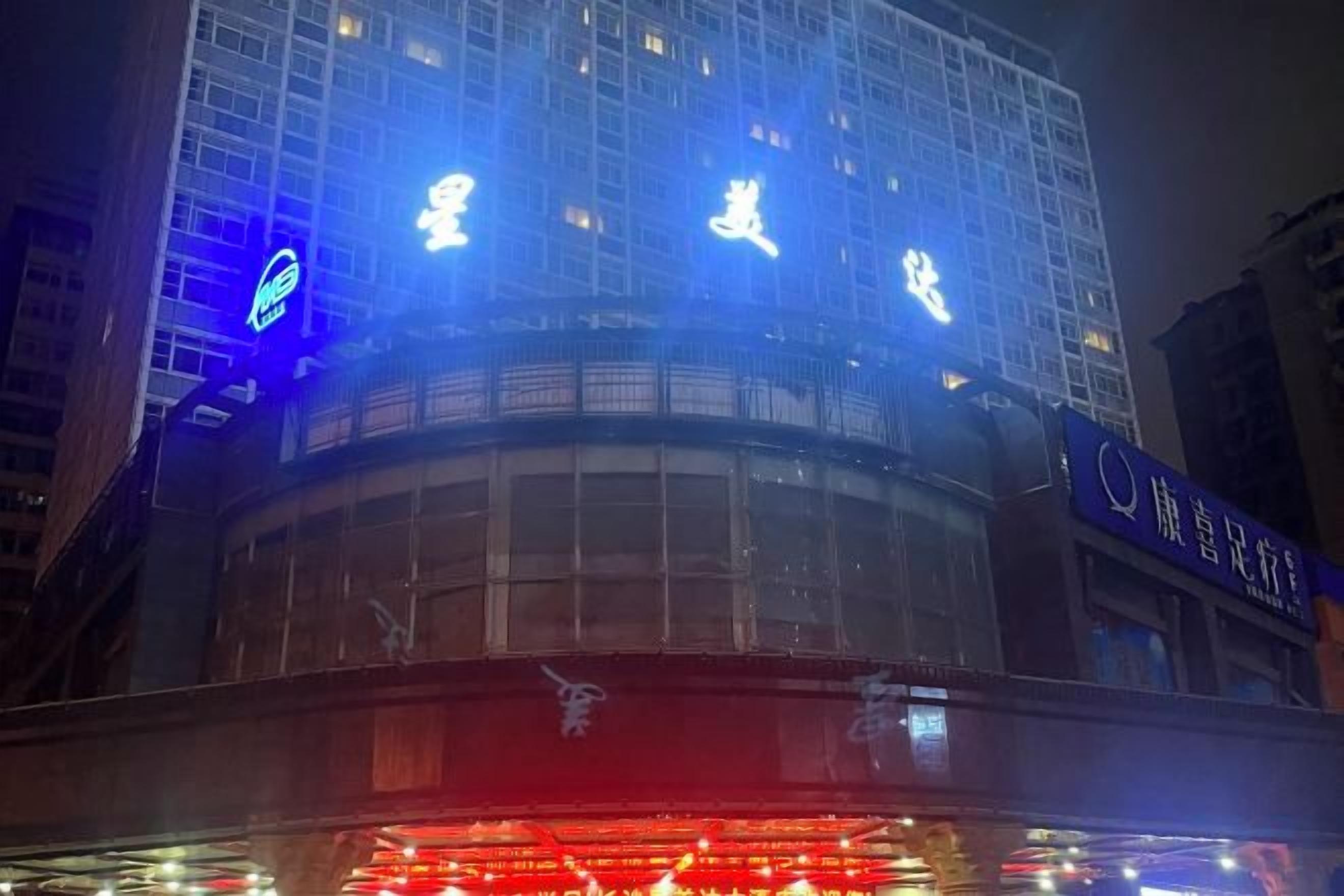 A building with illuminated signage, a curved structure, and a visible entrance.