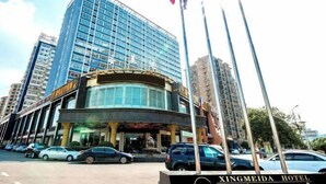 Un hotel moderno con fachada curva, varios pisos y una entrada destacada.