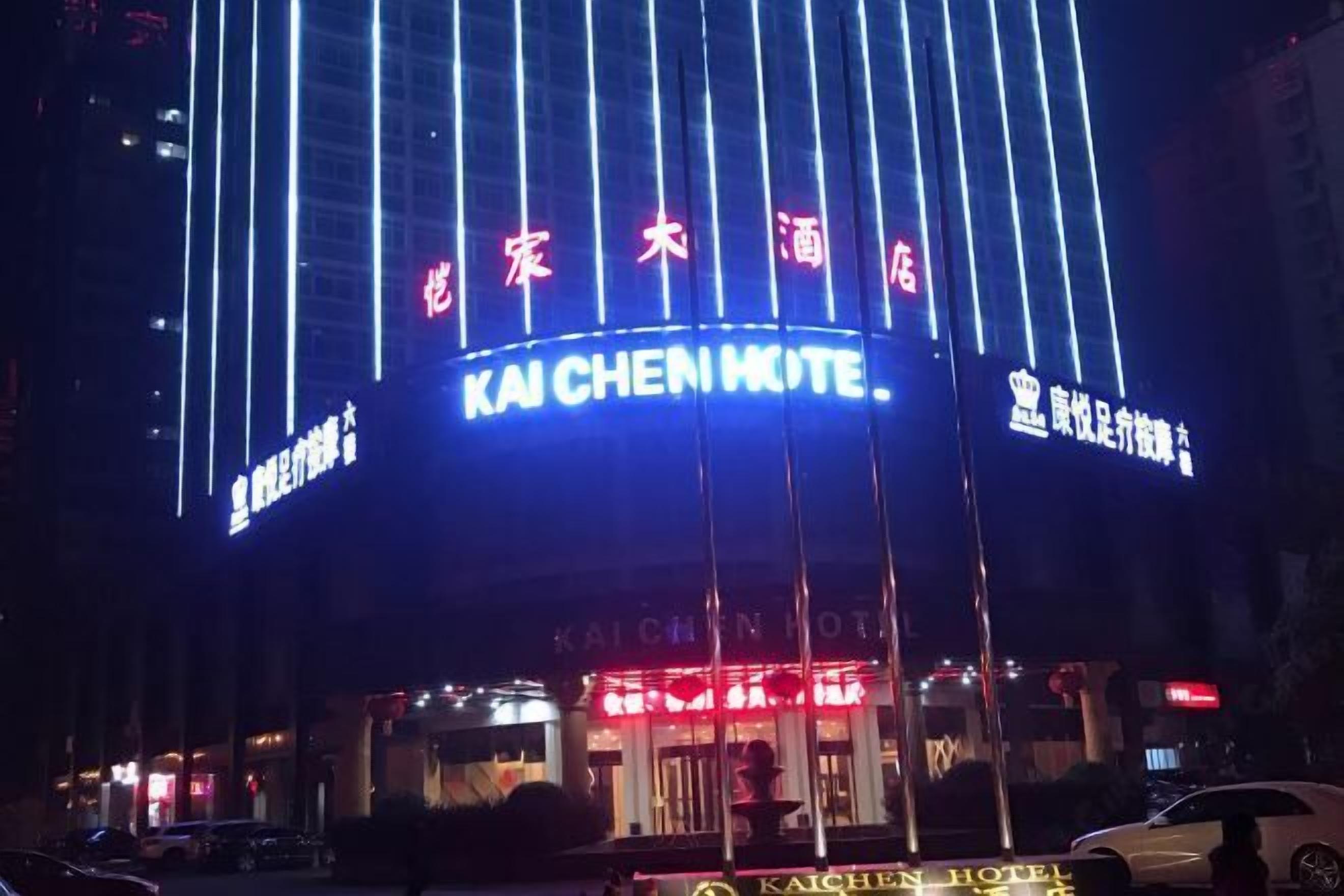 The exterior of the Kaichen Hotel with illuminated signage and vertical light strips.