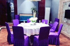 A round table with purple chairs, a white tablecloth, and a floral centerpiece. - Xing mei da Hotel (Changsha County)