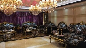 Un salón lujoso con sofás ornamentados, una araña y un suelo de mármol.