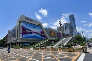 A modern building with a large digital billboard, a staircase, and a parking lot.