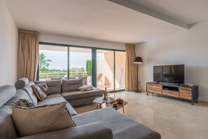 A modern living room with a sofa, TV, and a balcony view. - Apartment 'Altea La Nova' with Shared Pool & Wi-Fi (Altea la Vella)
